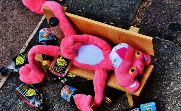 Pink animal passed out with alcohol bottles